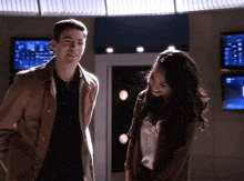 a man and a woman are standing next to each other in a dark room .