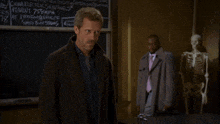 a man stands in front of a chalkboard that says you all suck