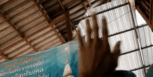 a person 's hand is reaching up towards a sign that says ' a ' on it