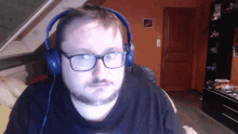 a man wearing headphones and glasses is looking at the camera