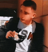 a young man is eating a slice of pizza with a fork .