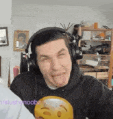 a man wearing headphones making a funny face with his tongue out .