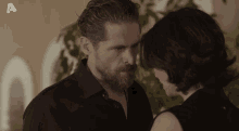 a man and a woman are looking at each other with the letter a visible in the corner