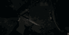 a person is standing in a dark room with snow falling from the ceiling .