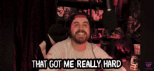 a man sitting in front of a microphone with the words that got me really hard below him