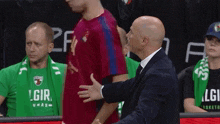 a man wearing a green shirt that says lgir