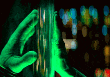 a person 's hand is glowing in green light