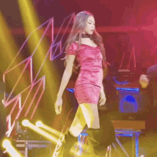 a woman in a red dress and black boots is dancing on a stage
