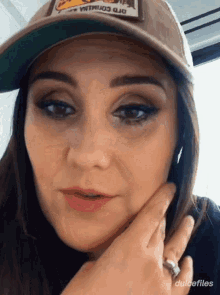 a close up of a woman wearing a hat with a patch that says dulcefiles