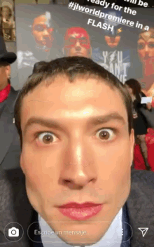a man taking a selfie in front of a poster that says #jlworldpremiere in a flash