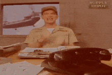 a man in a military uniform screams in front of a sign that says supply depot