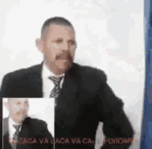 a man in a suit and tie is standing in front of a wall .