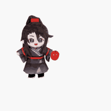 a stuffed doll is holding a red apple in his hand