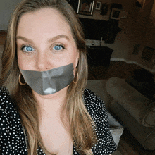 a woman with duct tape on her mouth and earrings