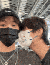 two people wearing face masks with one wearing a necklace that says ' snoopy ' on it