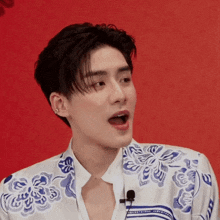 a young man wearing a blue and white shirt with a microphone on his neck
