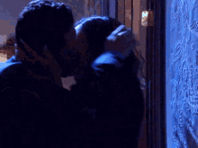 a man and a woman kissing in front of a door
