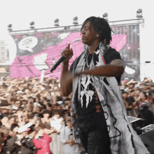 a man singing into a microphone in front of a crowd of people