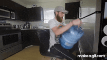 a man with a beard is carrying a large bottle of water in a kitchen ..