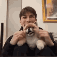 a man is holding a small dog in his arms .