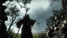 a man with a bow and arrow is standing in the woods