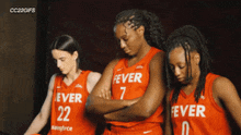 three female basketball players wearing red uniforms with fever written on them
