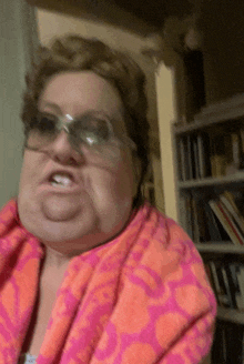 a woman wearing sunglasses and a pink and orange scarf