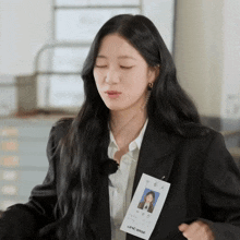 a woman wearing a black jacket and a lanyard that says lenc
