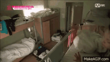 a person is laying on a bunk bed in a room with a bunch of bunk beds .