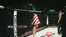 a fighter in a boxing ring with a geico sign in the background