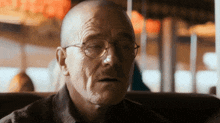 a bald man wearing glasses and a plaid shirt