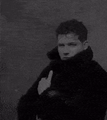 a black and white photo of a man in a coat