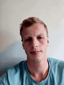 a man wearing a blue shirt is looking down at the camera