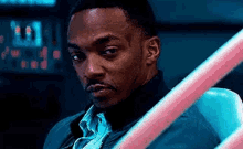 a close up of a man sitting in a chair with a pink railing in the background .