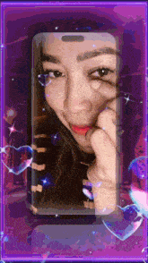 a woman 's face is displayed on a cell phone screen surrounded by hearts