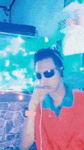 a man wearing sunglasses and headphones is smoking a cigarette in front of a fish tank