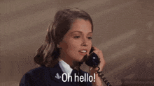 a woman in a navy uniform is talking on a telephone and saying oh hello