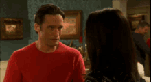 a man and woman are looking at each other in a living room .