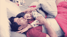 a man and a woman laying on a bed with the word vivo on the blanket