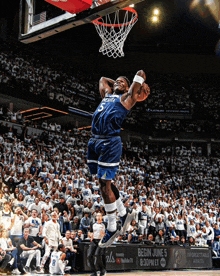 a basketball player wearing a minnesota uniform is jumping in the air