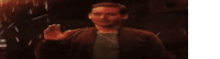 a man is standing in front of a fireball in a dark room .