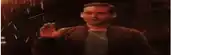 a man is standing in front of a fireball in a dark room .
