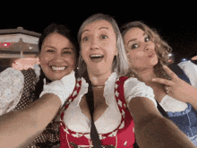 three women are posing for a picture and one of them is making a face