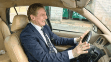 a man in a suit is driving a car