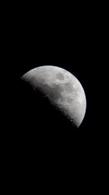 a black and white photo of a half moon in the night sky