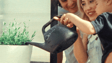 a woman and a child watering plants with a watering can that says " on it here "