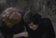 a blurry picture of a man laying on the ground with his hands on his head .