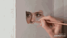 a close up of a person painting a woman 's face with a brush .