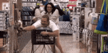 a man is being pushed in a shopping cart by a woman .