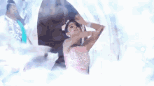 a girl in a pink dress is dancing in front of a castle